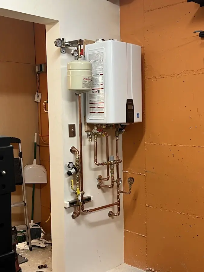 Plumbing technician inspecting water heater connections in Tredyffrin